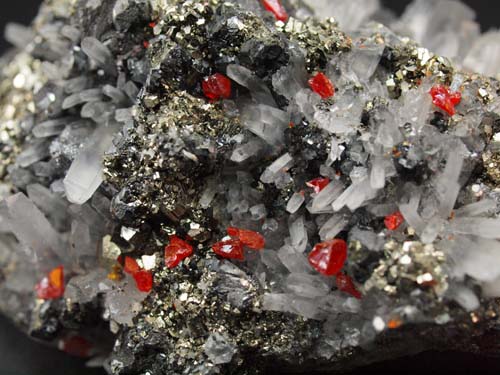 cristalls de quars amb cristalls de realgar i cristalls de pirita sobre cristalls d'esfalerita i galena.<br>Mida 4cm x 9cm x 3,5cm